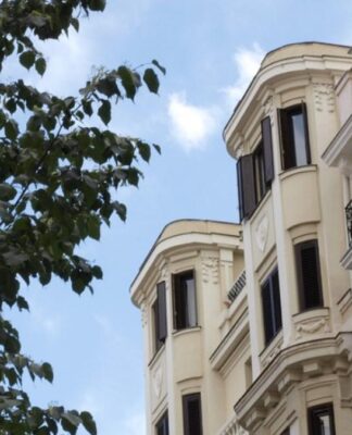 edificio señorial de fachada antigua color crema con un fondo de cielo azul